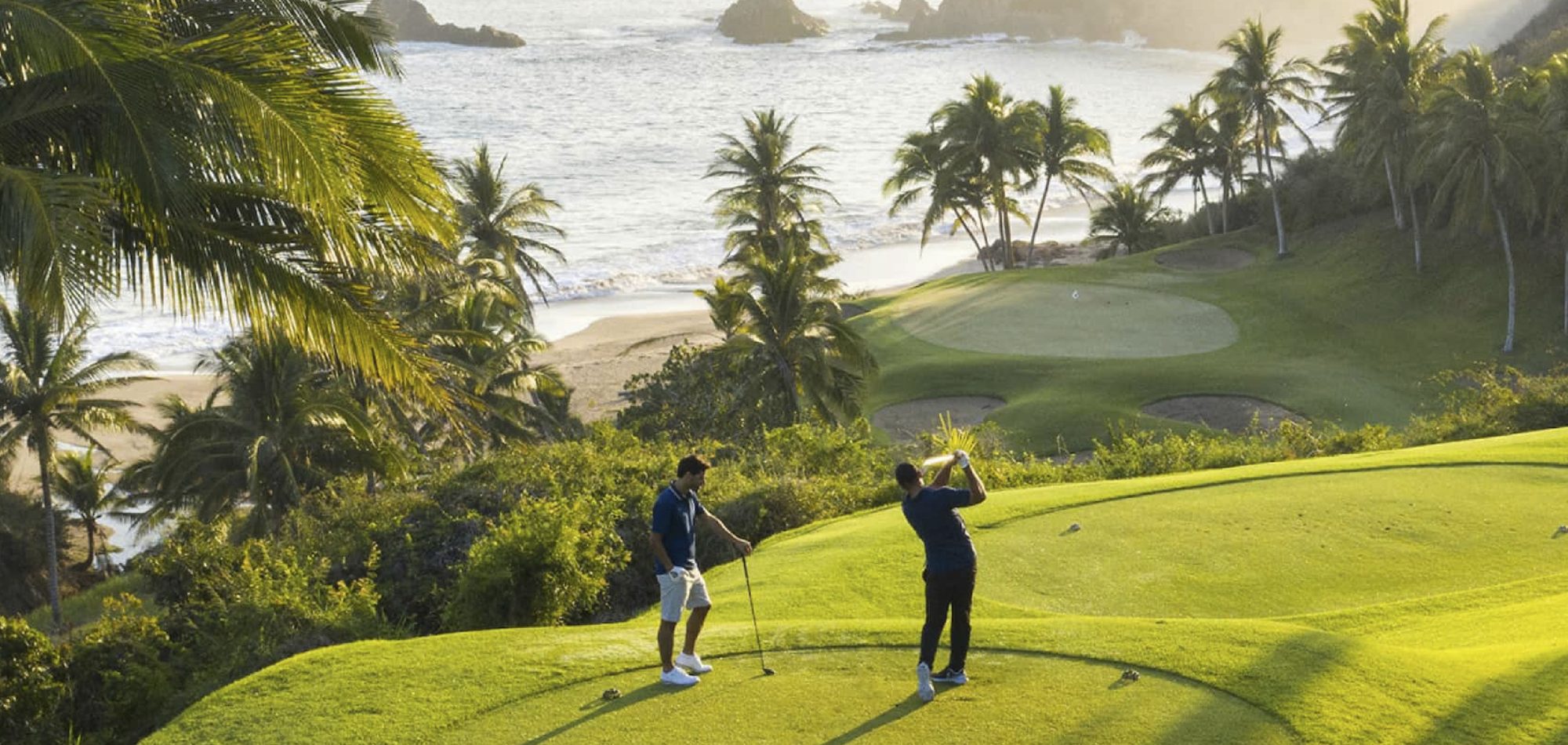 Golfistas en el campo de Four Seasons Resort Tamarindo con el Pacífico al fondo
